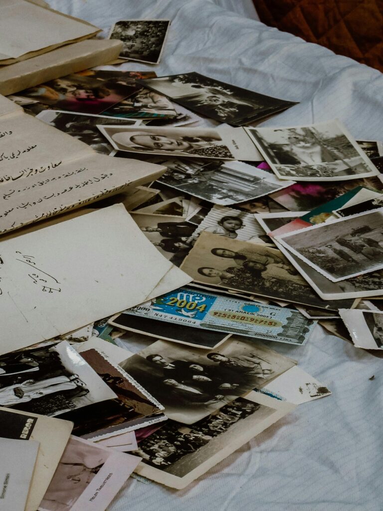A nostalgic collection of old photographs and papers on a fabric surface.